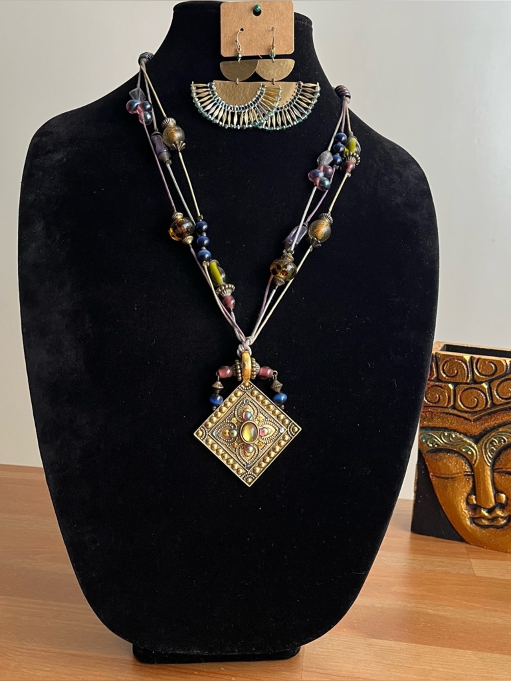 Vintage-style beaded necklace with a square, metal pendant paired with earrings